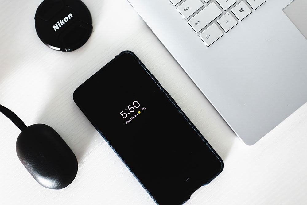Android phone and a Macbook sitting on a desk
